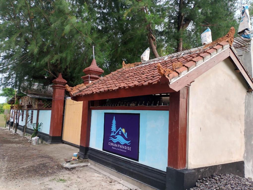 a sign on the side of a building at Cemara Paradise Homestay in Pulau Gilimelayu