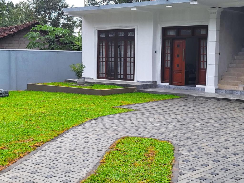 a house with a brick walkway in front of it at Nimsara Homes in Veyangoda
