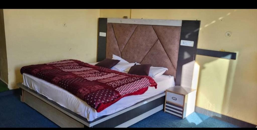 a bedroom with a large bed with a red comforter at Lekhwar in Chamba