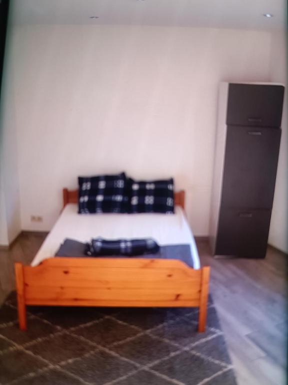 a bedroom with a bed with a wooden foot board at Nke Roméo in Liège
