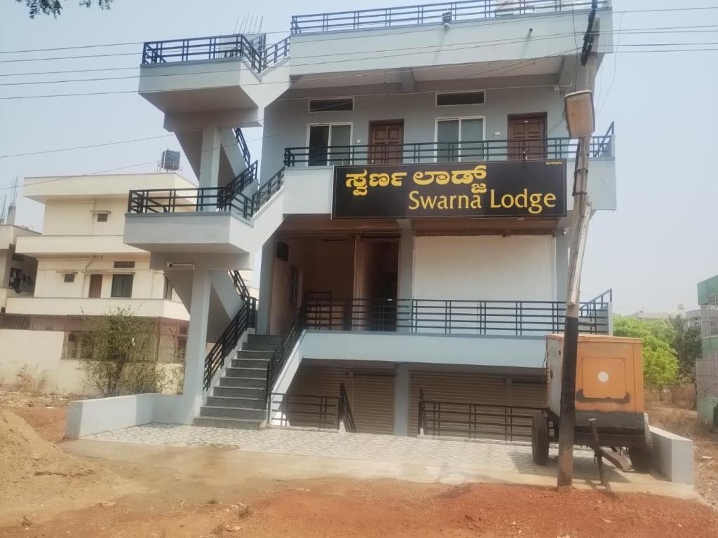 a building with a sign that reads star oops swami lodge at Swarna Lodge in Badami