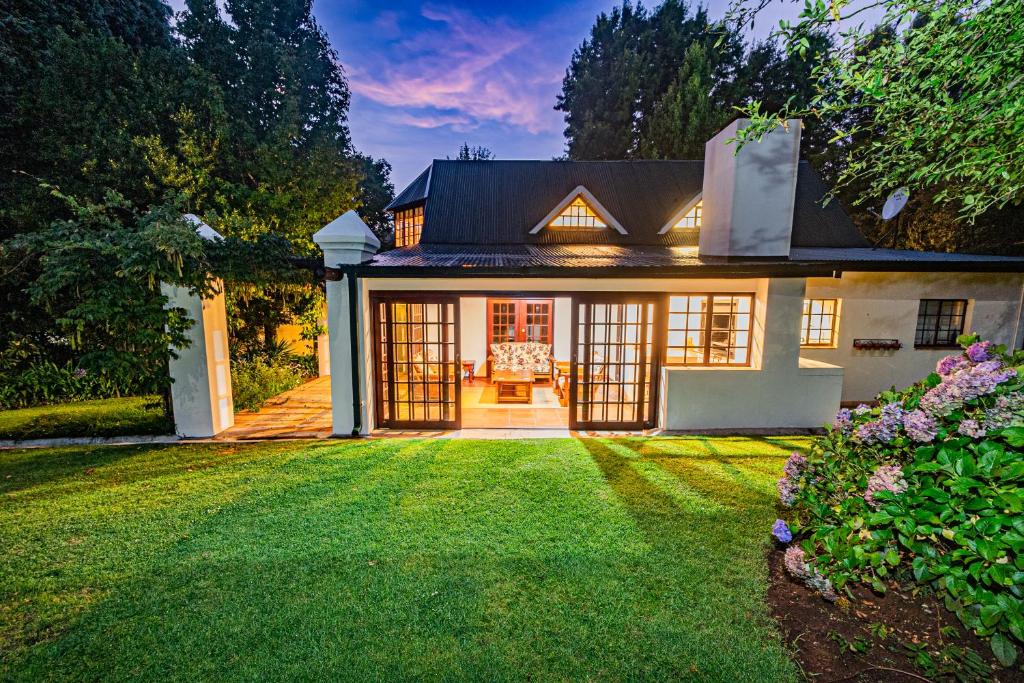 a house with a lawn in front of it at Crossroads Cottage in Dullstroom