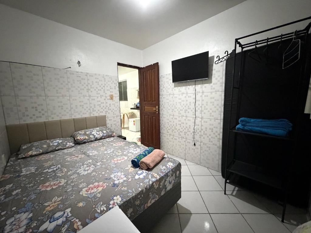 a bedroom with a bed and a flat screen tv at Apto 04 em São Bras in Belém