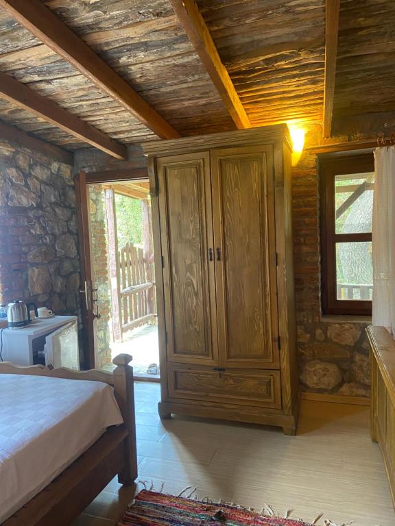 a bedroom with a bed and a wooden cabinet at Pavelin yeri in Altınoluk