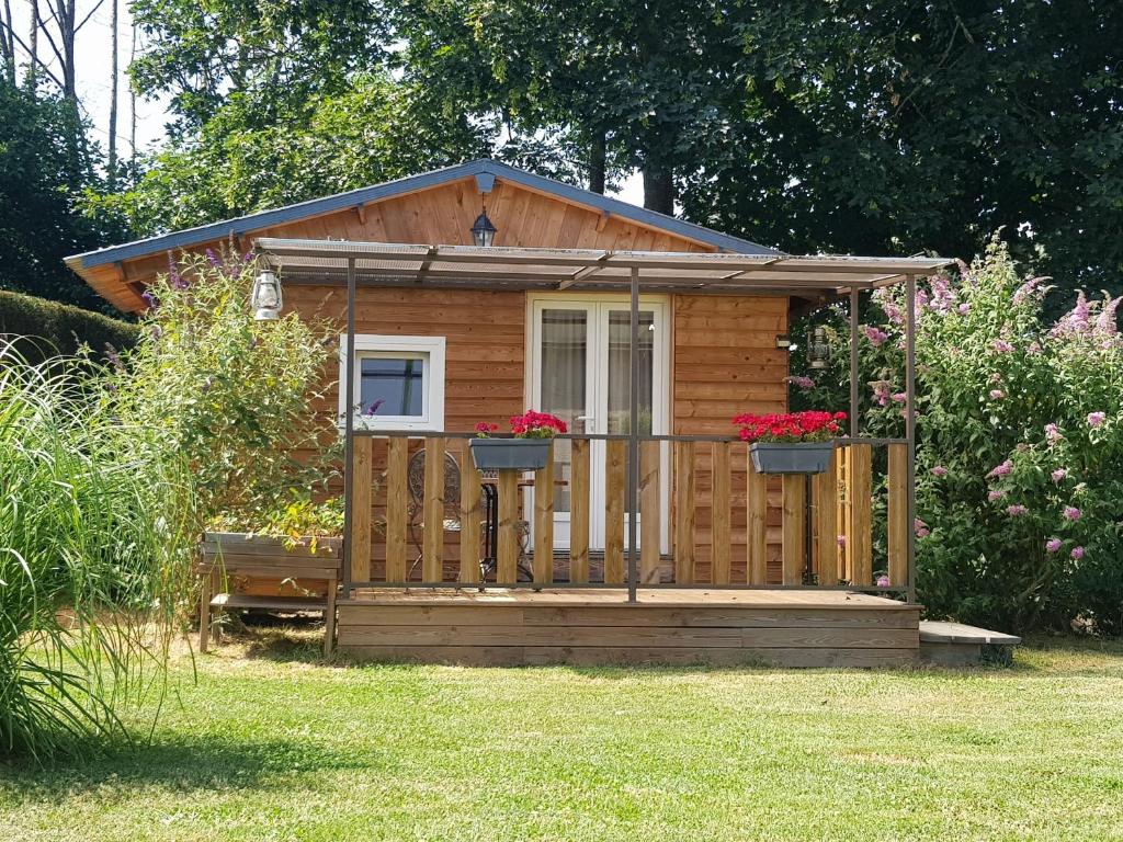 a wooden cabin with a balcony in a yard at Le Riolet in Marsac-en-Livradois
