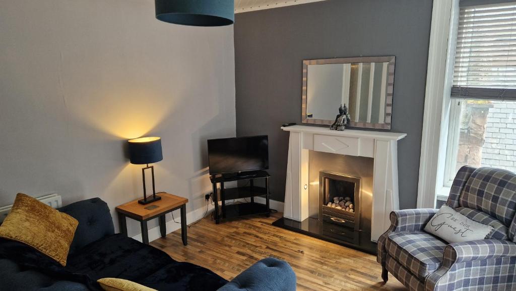 a living room with a couch and a fireplace at The Geo Apartment in Montrose