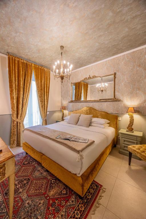 a bedroom with a large bed and a chandelier at Corte Realdi Suites Arena Verona in Verona