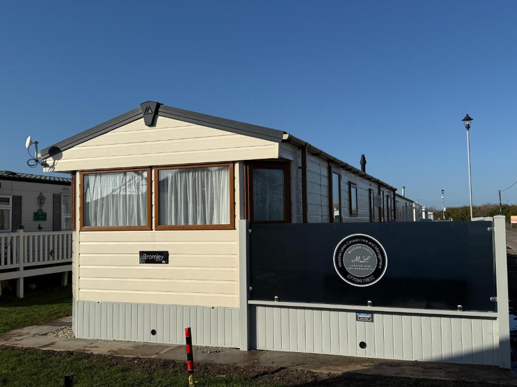 a black and white house with a garage at Sunnymede D1 - Hot Tub Caravan - Sleeps 10 - Fantasy Island, Ingoldmells - Meadow Lakes Caravan & Lodge Hire in Ingoldmells