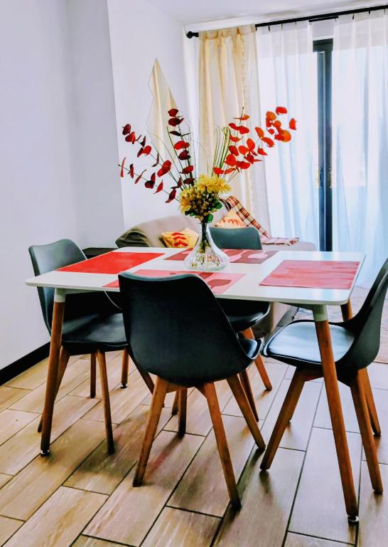a dining room table with chairs and a vase with flowers at Alojamiento zona 12 in Boca Monte