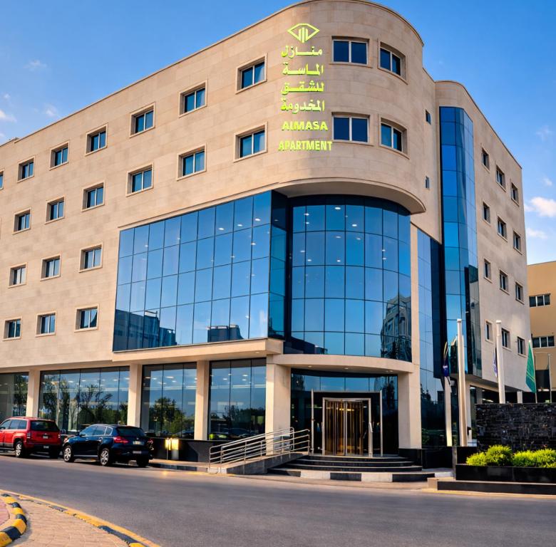 a building with a sign on the front of it at منــازل الماسة للشقق المخدومة in Unayzah