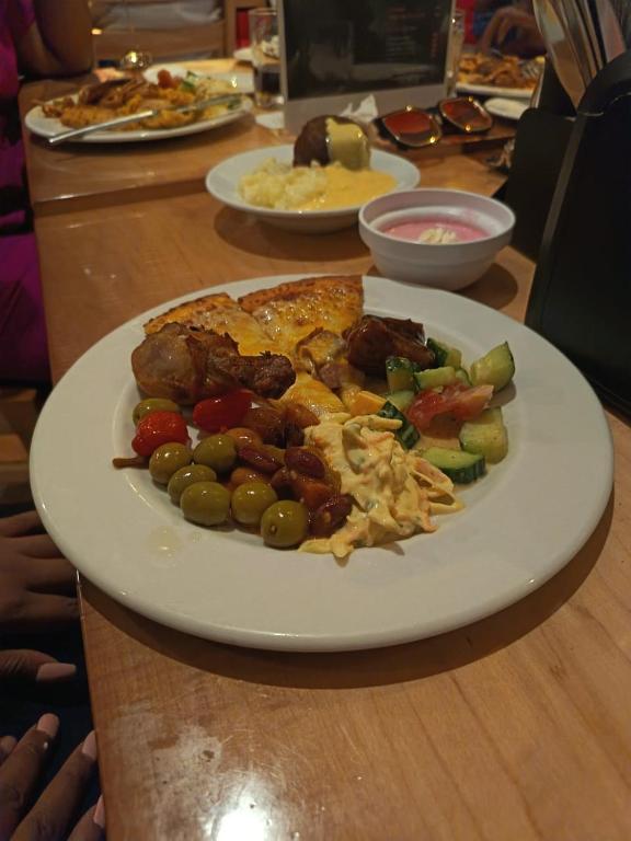 a plate of food with meat and vegetables on a table at Mamela BNB in Elandsfontein