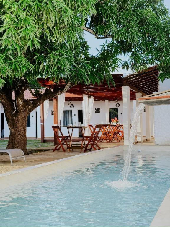 a swimming pool with a fountain in front of a house at Pousada da Mangueira 1 in Barreirinhas