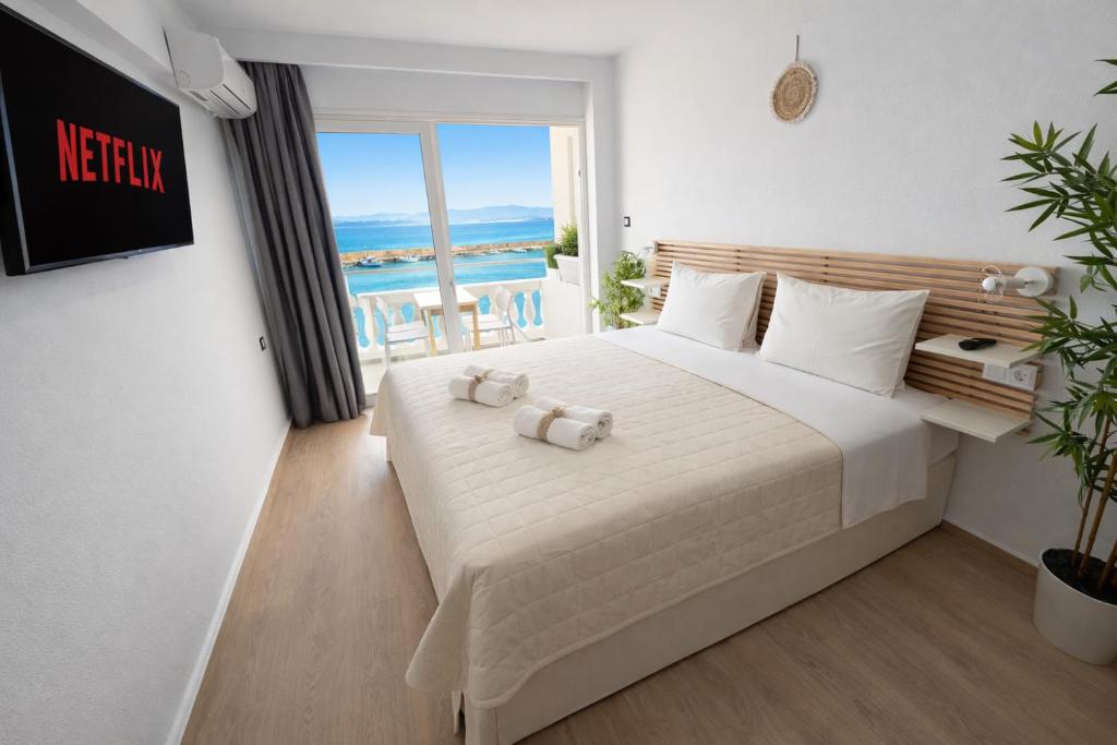 a bedroom with a bed with a view of the ocean at Opal Apartments Luxury by the Sea in Hersonissos