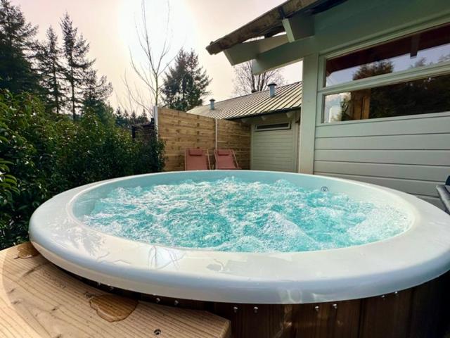 Eine große Badewanne steht auf einer Holzterrasse. in der Unterkunft Chalet Marron in Durbuy