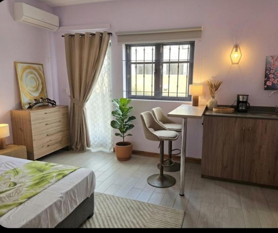 a bedroom with a bed and a desk and a table at Skyra Villa in Mahébourg