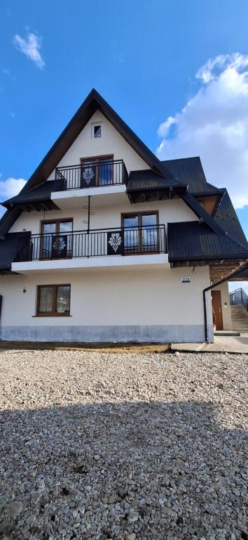 a white house with a black roof at Przy Potocku in Czarna Góra