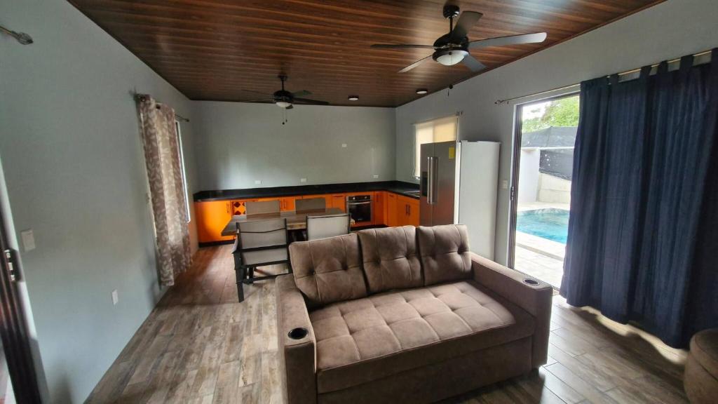 a living room with a couch and a table and a kitchen at House with a private pool in Ojochal