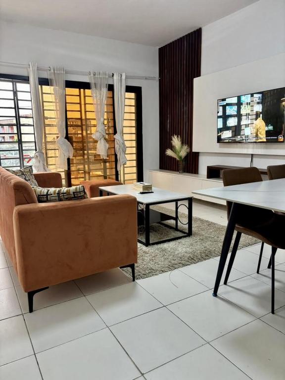 a living room with a couch and tables at Au cœur de Angré la djibi in Cocody