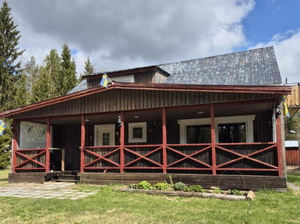 a house with a gambrel roof with red trim at Helt hus i lilla Vuotner in Arvidsjaur