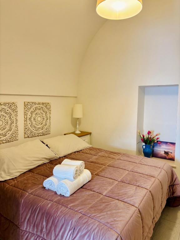 a bedroom with a bed with towels on it at Affittacamere Nalì in Polignano a Mare