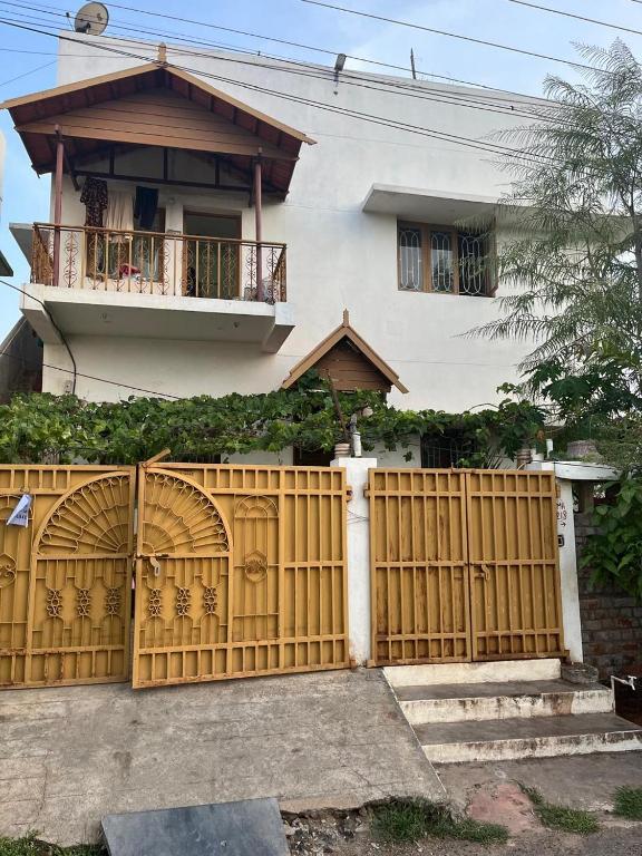 a house with a wooden gate and a fence at Natural bliss in Tiruchirappalli