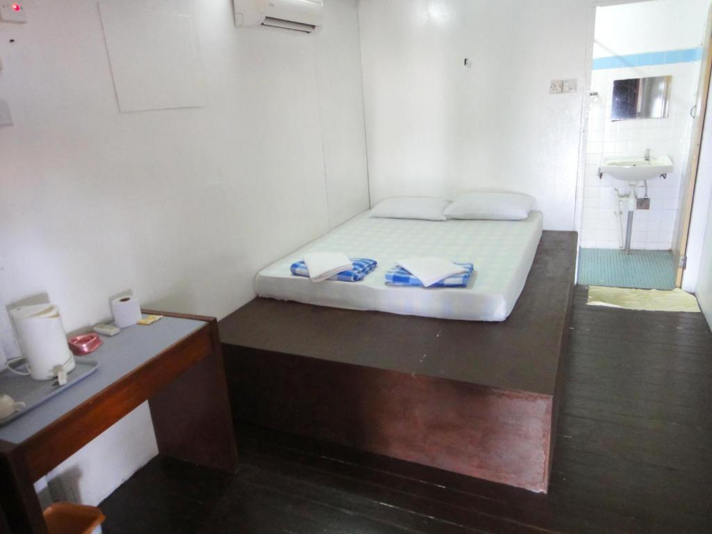 a small room with a bed and a sink at Coral Reef Holidays in Tioman Island