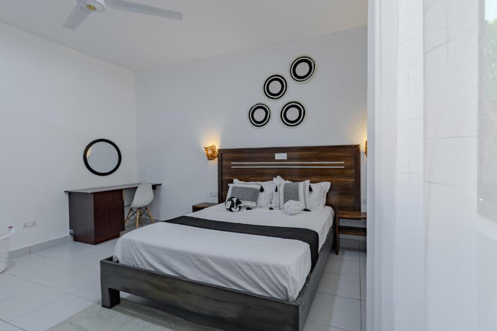 a bedroom with a large bed with two pillows at Wendy's Da-Azizi Homes Diani 2 in Diani Beach
