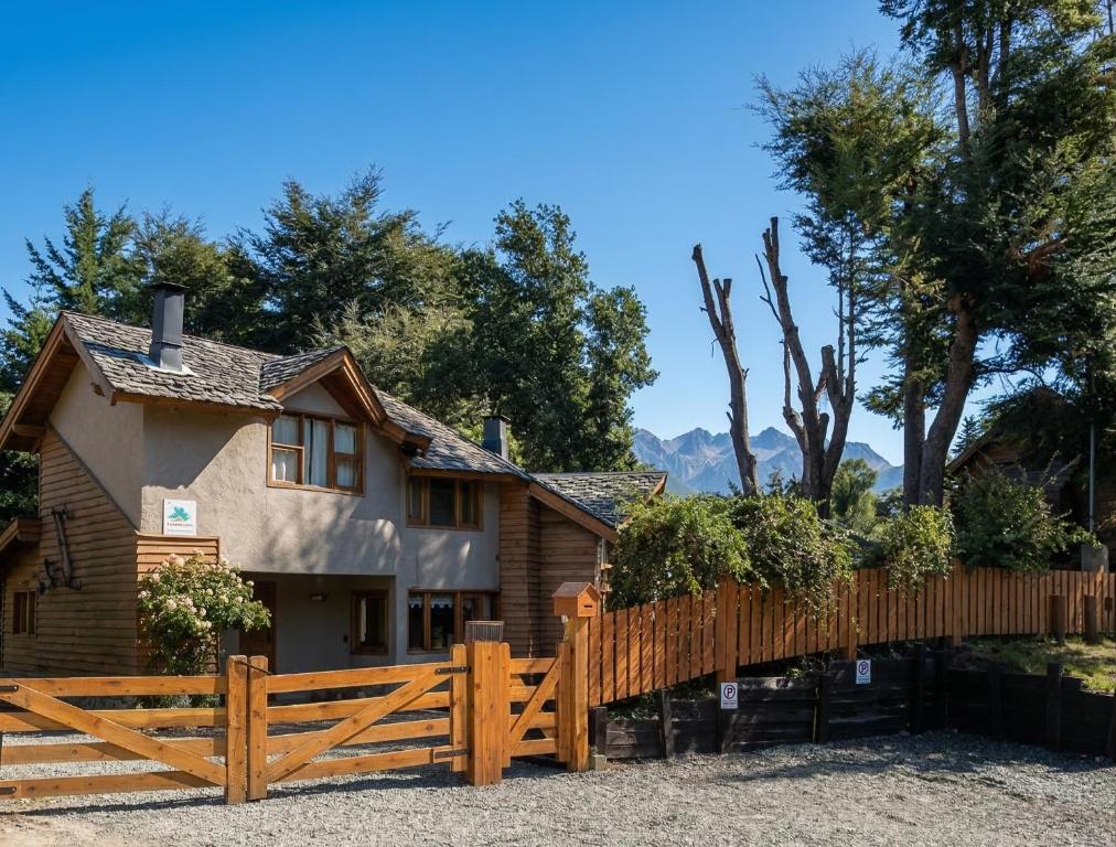 a wooden fence in front of a house at Lelikelen Cabañas del Bosque in Villa La Angostura