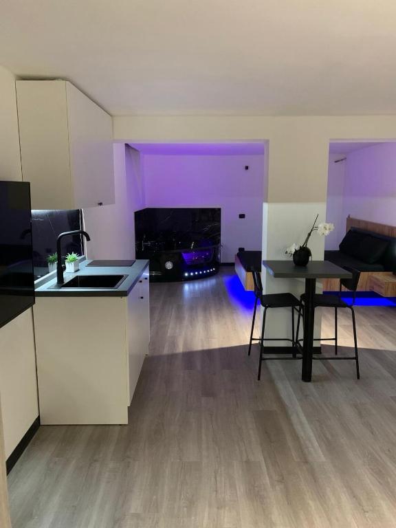 a kitchen and living room with a table and a couch at Sanu Home B&B in Lonate Pozzolo