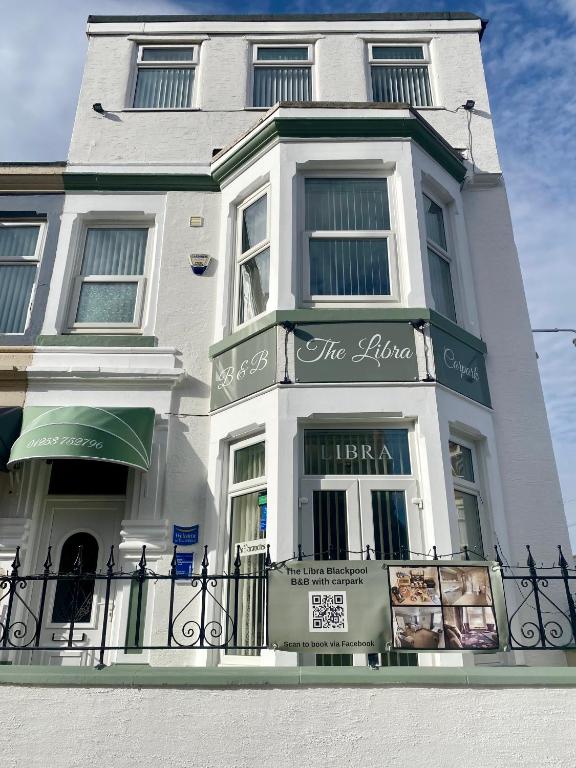 a white building with a sign on it at The Libra - Adults Only B&B with guaranteed carpark in Blackpool