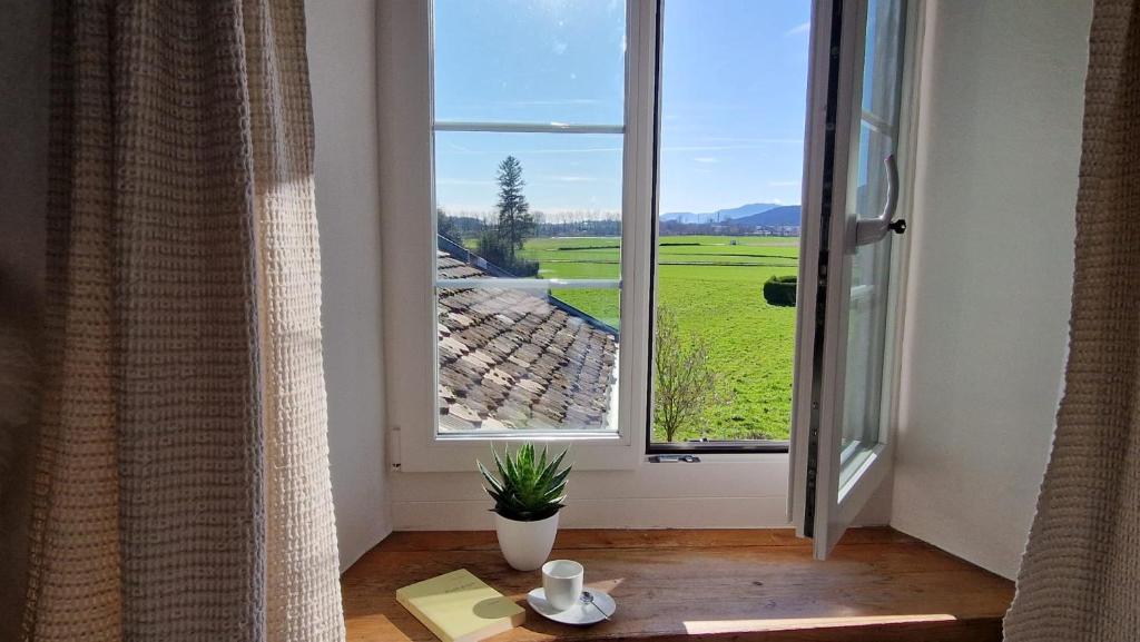 a room with a window and a table with a book at Au Bourg in Le Landeron