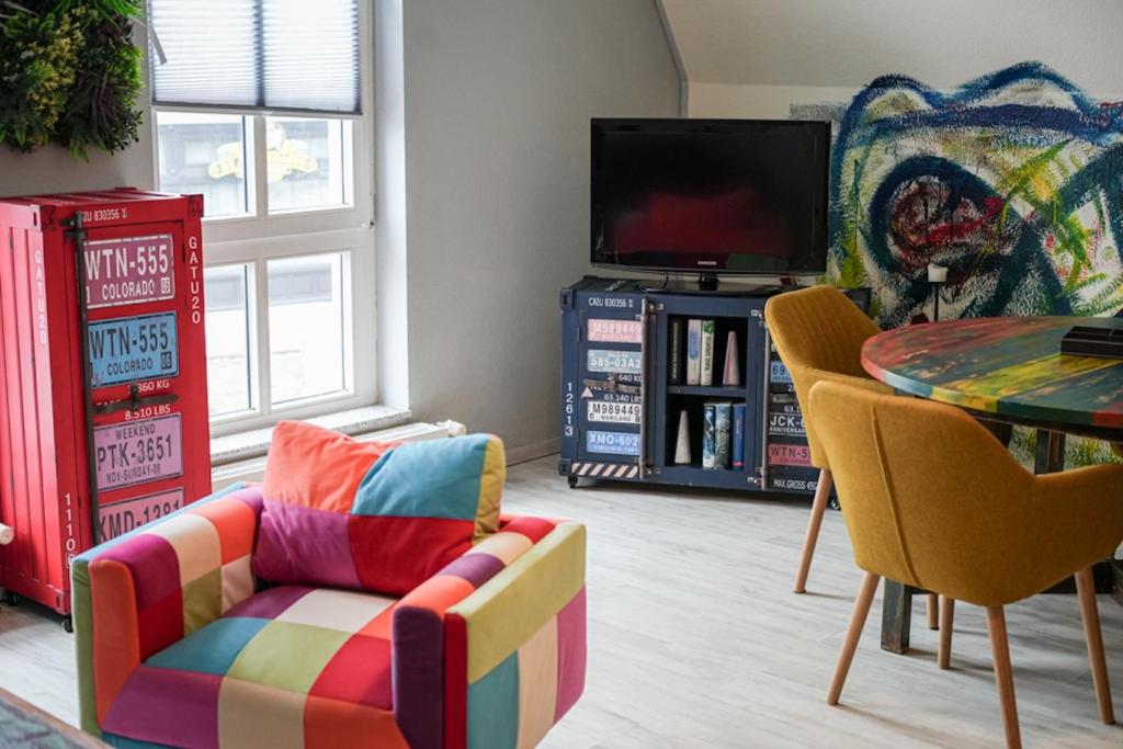 a living room with a colorful chair and a table at Ostsee43 - Apartment Ole in Rostock