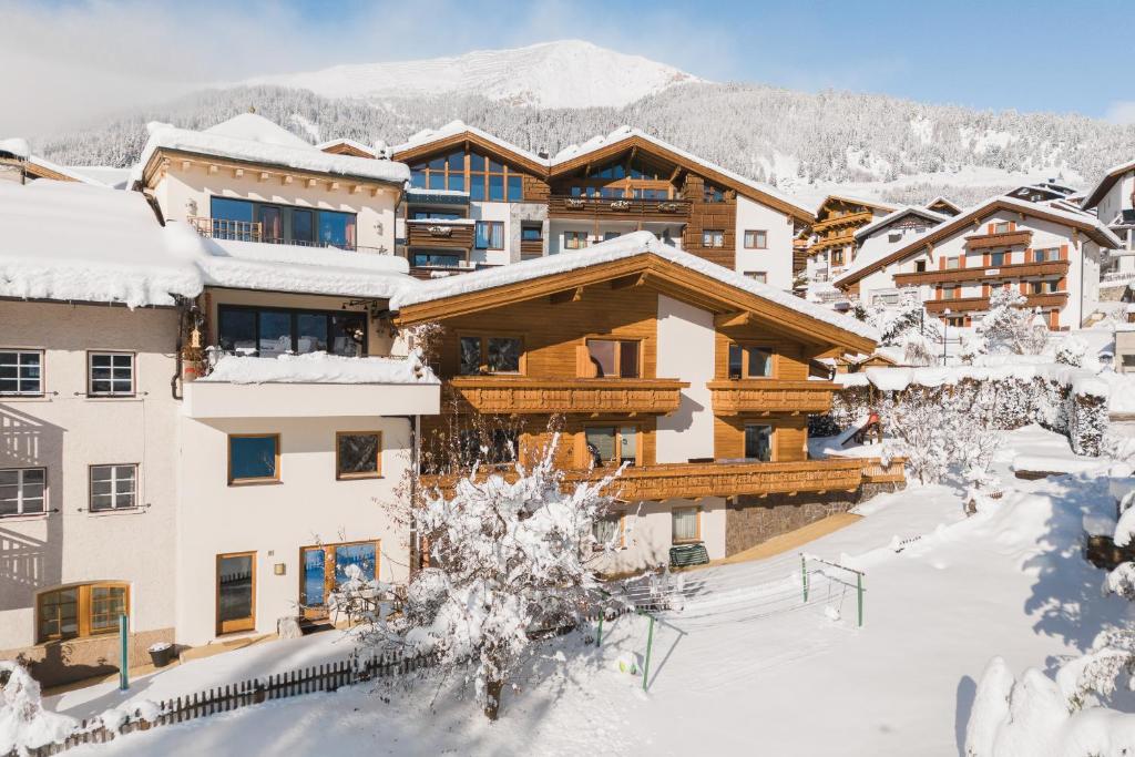 a ski lodge in the snow with mountains in the background at An der Via Claudia Augusta in Fiss