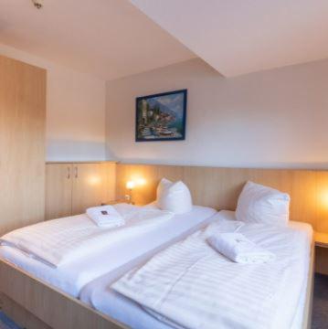 a bedroom with a large white bed with two pillows at Altes Posthaus Ahlhorn in Großenkneten