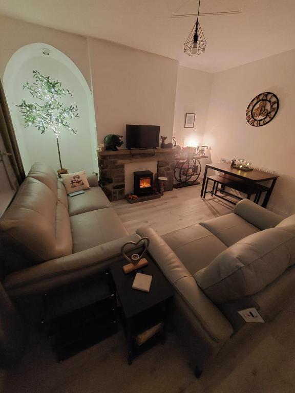 a living room with a couch and a fireplace at Harrys Hideaway Cottage in Haworth