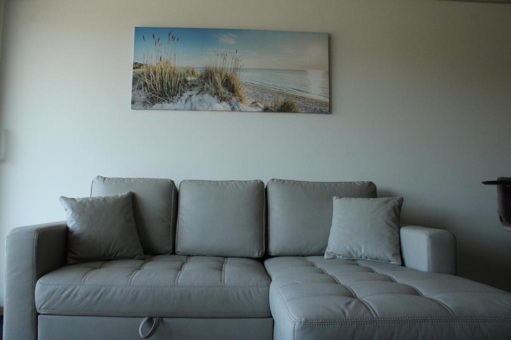a couch in a living room with a picture on the wall at Studio Avondzon in Blankenberge