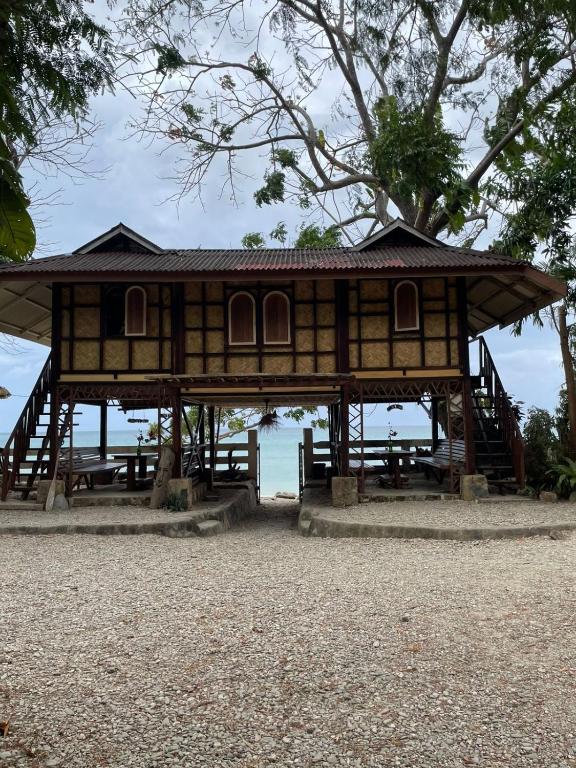 a tree house on the beach with tables at 74YOU Beach Resort and Restaurant in Puerto Princesa City