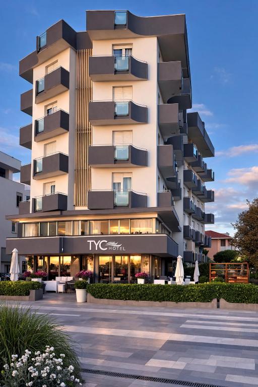 a tall apartment building with a parking lot at Hotel TYC in Rimini