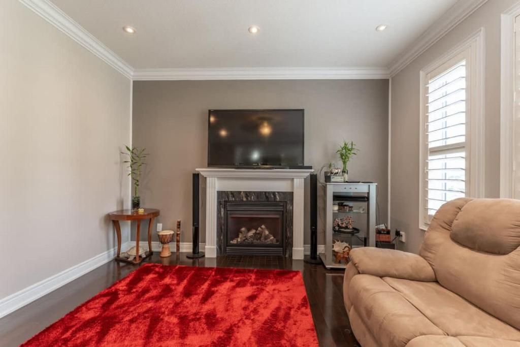a living room with a couch and a fire place at Spacious 7BR Home with Private Yard & Fast WiFi! in Brampton