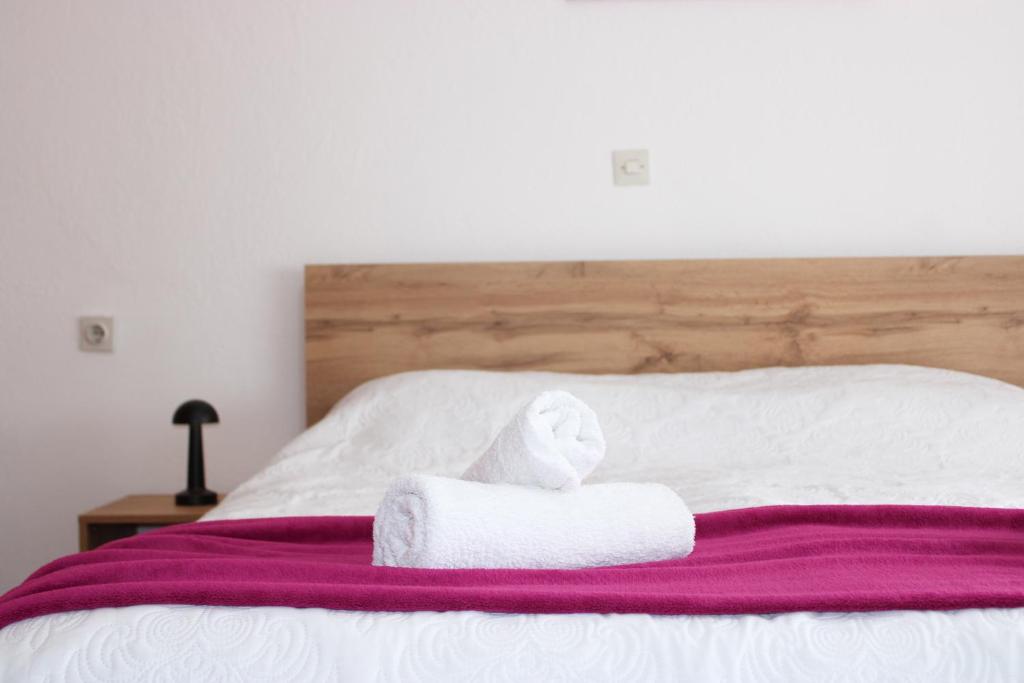 a bed with two towels on top of it at Corner Five in Negotino