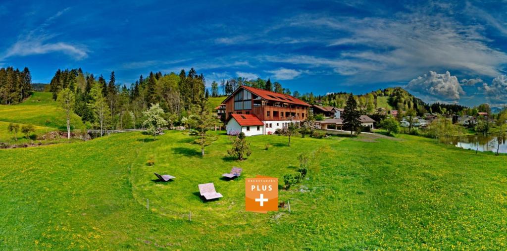 a house on a hill with a sign in the grass at Eibele Chalets in Oberstaufen