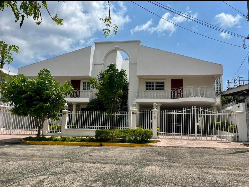 a white house with a white fence in front of it at Casa Duplex Privada con Piscina in Panama City