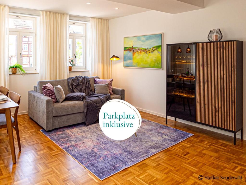 a living room with a couch and a cabinet at Apartments am Linggplatz - Ruhige Lage in der Fußgängerzone - Self-Check-in - Parkhaus inklusive - Schnelles WLAN in Bad Hersfeld