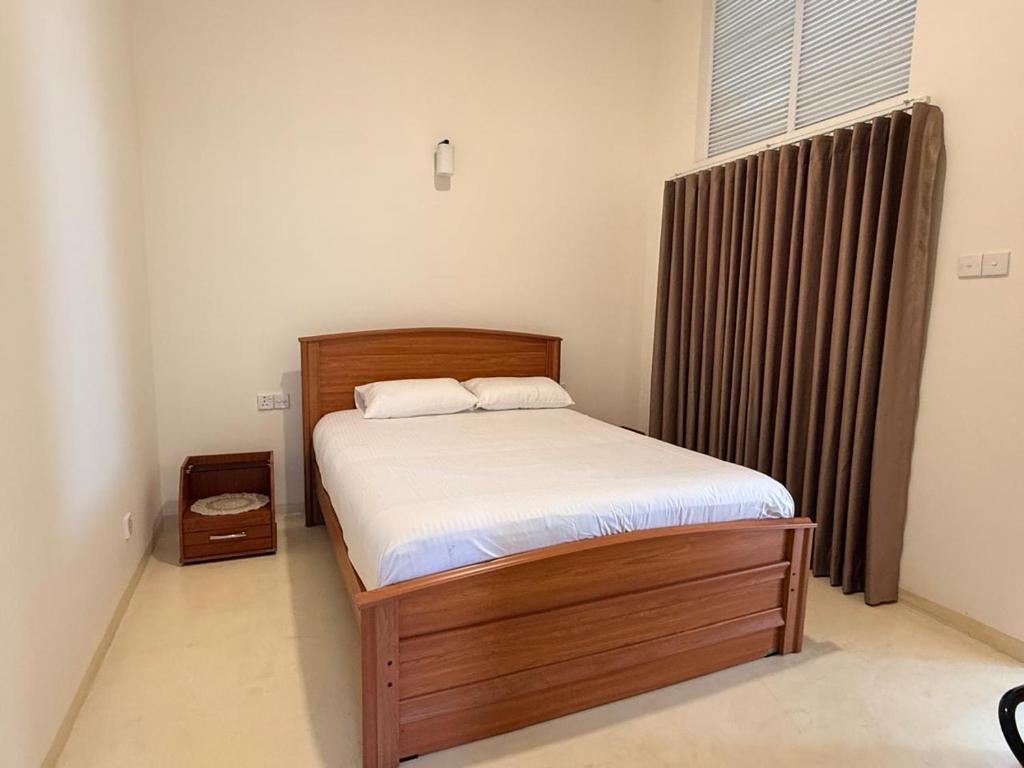 a bedroom with a bed with a wooden bed frame at Misty Hues in Kandy