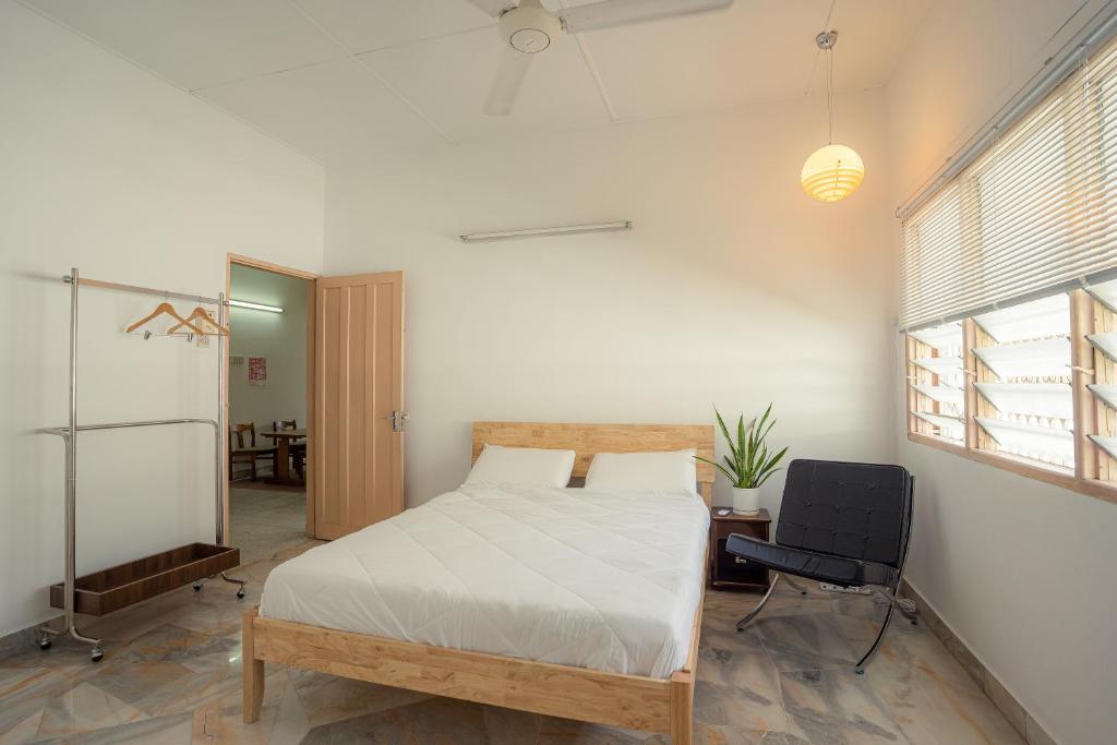 a bedroom with a bed and a desk and a chair at Tido Home, private queen room w bathroom, shared public area in Ipoh