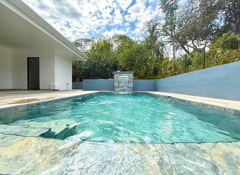 a swimming pool in the backyard of a house at Coral Breeze in Puntarenas