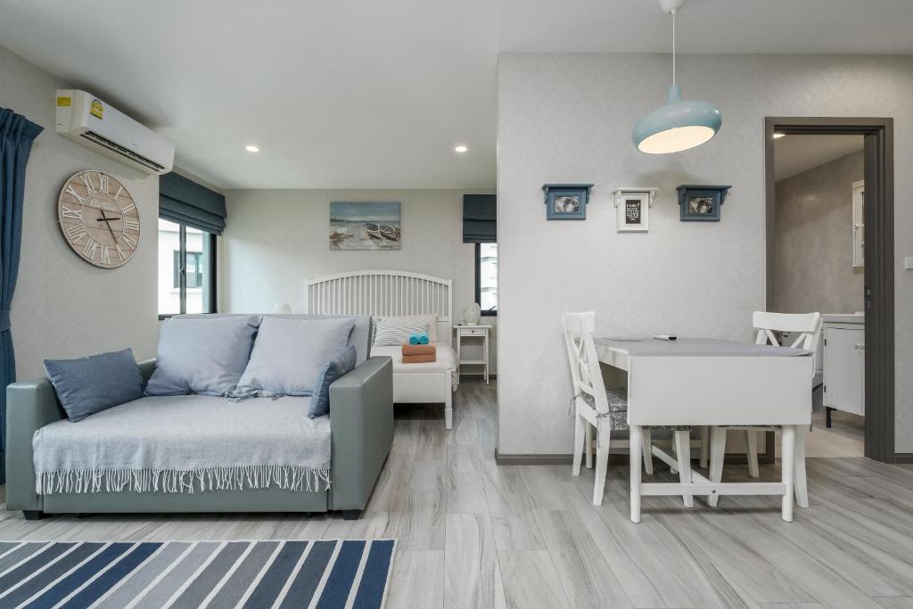 a living room with a couch and a dining room at Cozy Studio Apartment E414 in Phuket