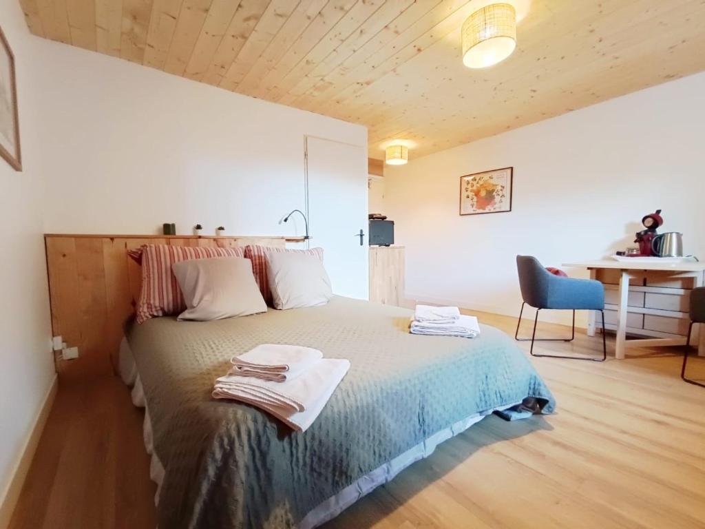a bedroom with a bed with towels on it at La tournette - Sur la route d'Annecy in Alby