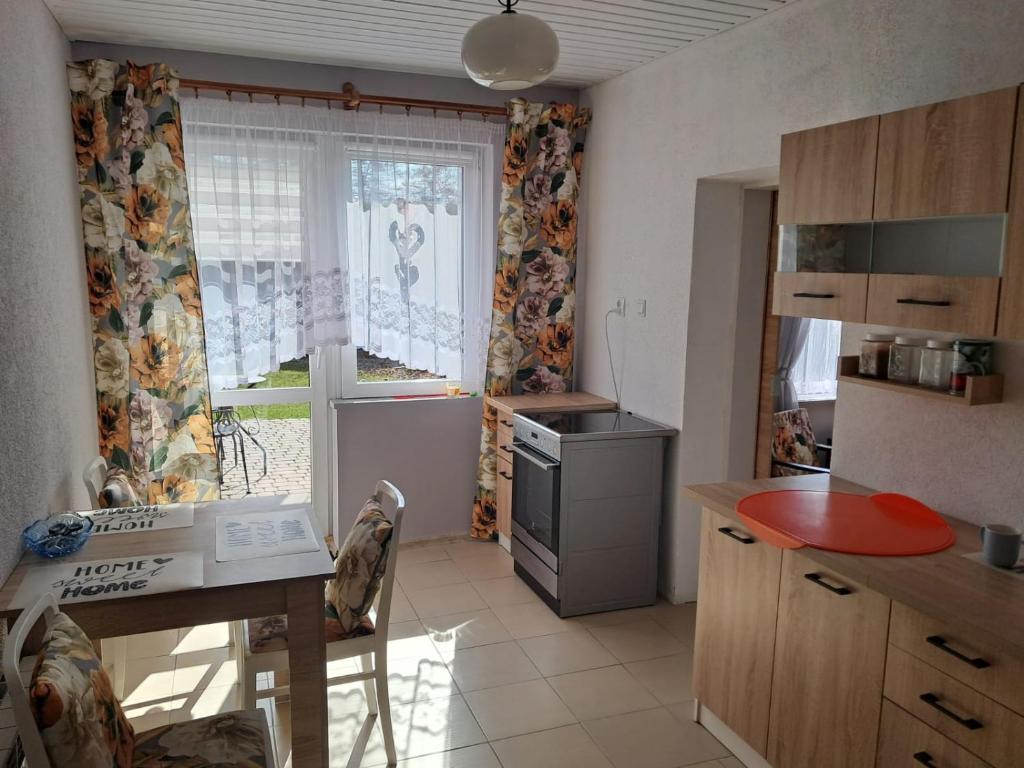 a kitchen with a table and a window with curtains at Przystań nad Dłubnią in Wysocice