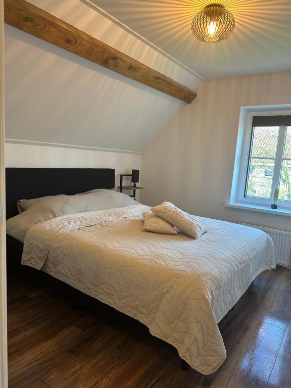 a bedroom with a bed and a chandelier at Op t hiem in Nes